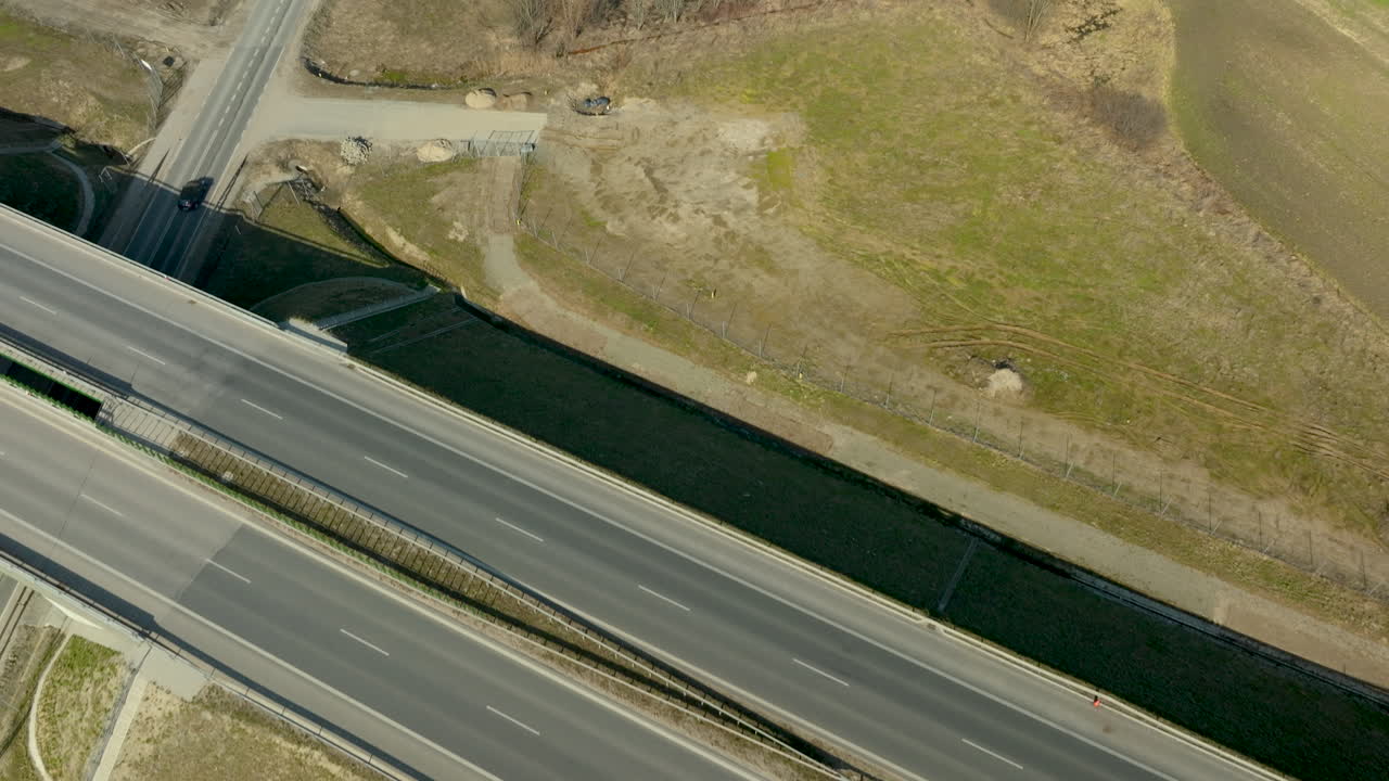 несколько автомобилей пересекают завершенный участок шоссе