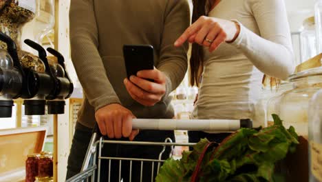 sección media de compras de pareja en el supermercado 4k