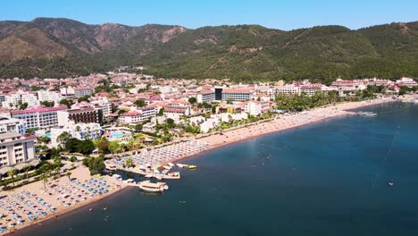 drone flight over the resort town and hotels against the backdrop of the mediterranean sea blue sky beach and bay with yachts and a pier