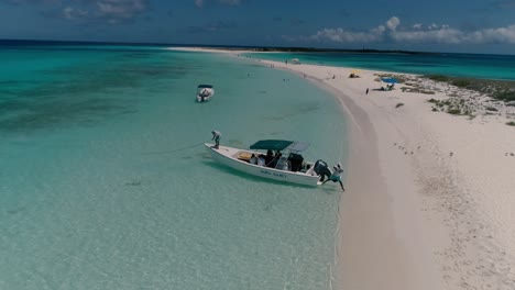 el marinero y el capitán anclan la lancha motora en la arena para llegar a la playa caribeña, amarran un barco lleno de turistas, los roques
