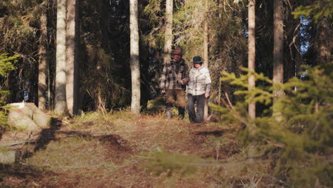 sweet senior couple with happy dog in the forest recreation walk in pine forest in finland