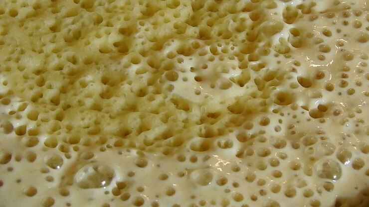 Food shot of some Homemade traditional Moroccan Baghrer in clay fryer , pancakes Baghrir or crapes with 1000 holes