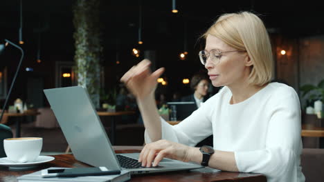 mujer trabajando en una computadora portátil en un café
