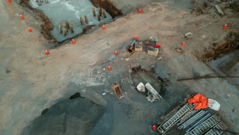 Aerial-shot-of-messy-construction-site-dirt-pit-foundation-of-building---empty