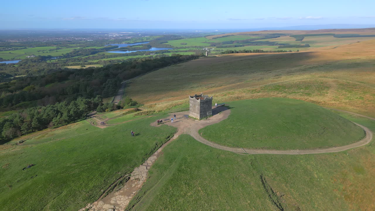 estructura de piedra en la cima de la colina con el camino y los turistas