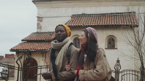 young diverse couple walking in old town