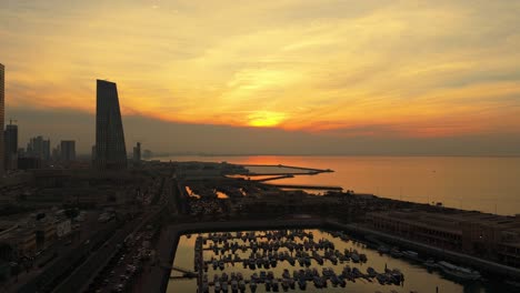 Stunning 4K aerial of Kuwait marina during golden hour with yachts, skyline, and glowing sunset. Perfect for tourism, luxury, real estate, or Middle East-themed visuals.