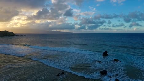 Flying-backward-over-the-coast-of-Maui,-Hawaii-at-sunset,-reverse-dolly