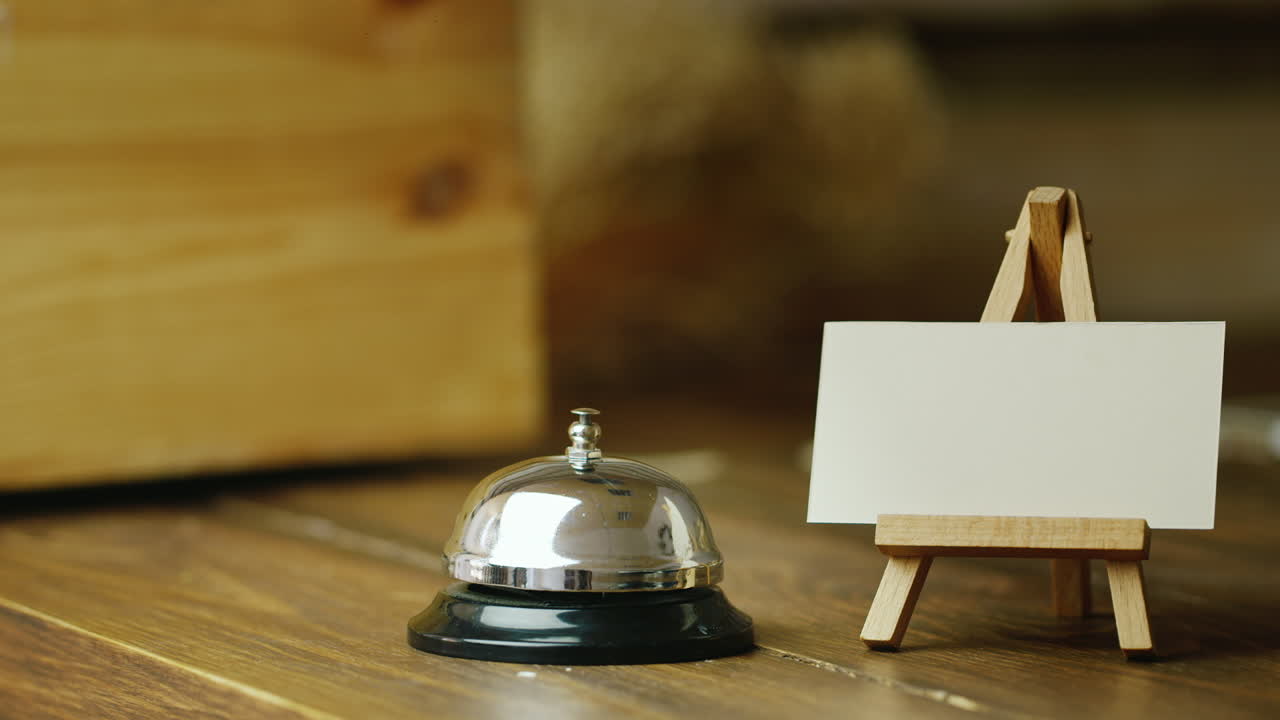 la mano golpea una llamada de escritorio al lado del plato sin texto para sus inscripciones