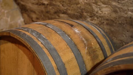 Close-up of old oak wine barrel with metal bands in wine cellar aging room