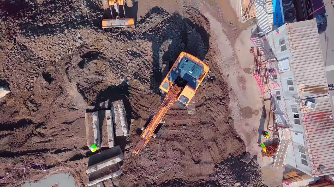 vista aérea de un gran sitio de construcción con varias máquinas de movimiento de tierra.