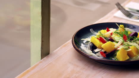 shaved fennel salad on a table by a window, pan