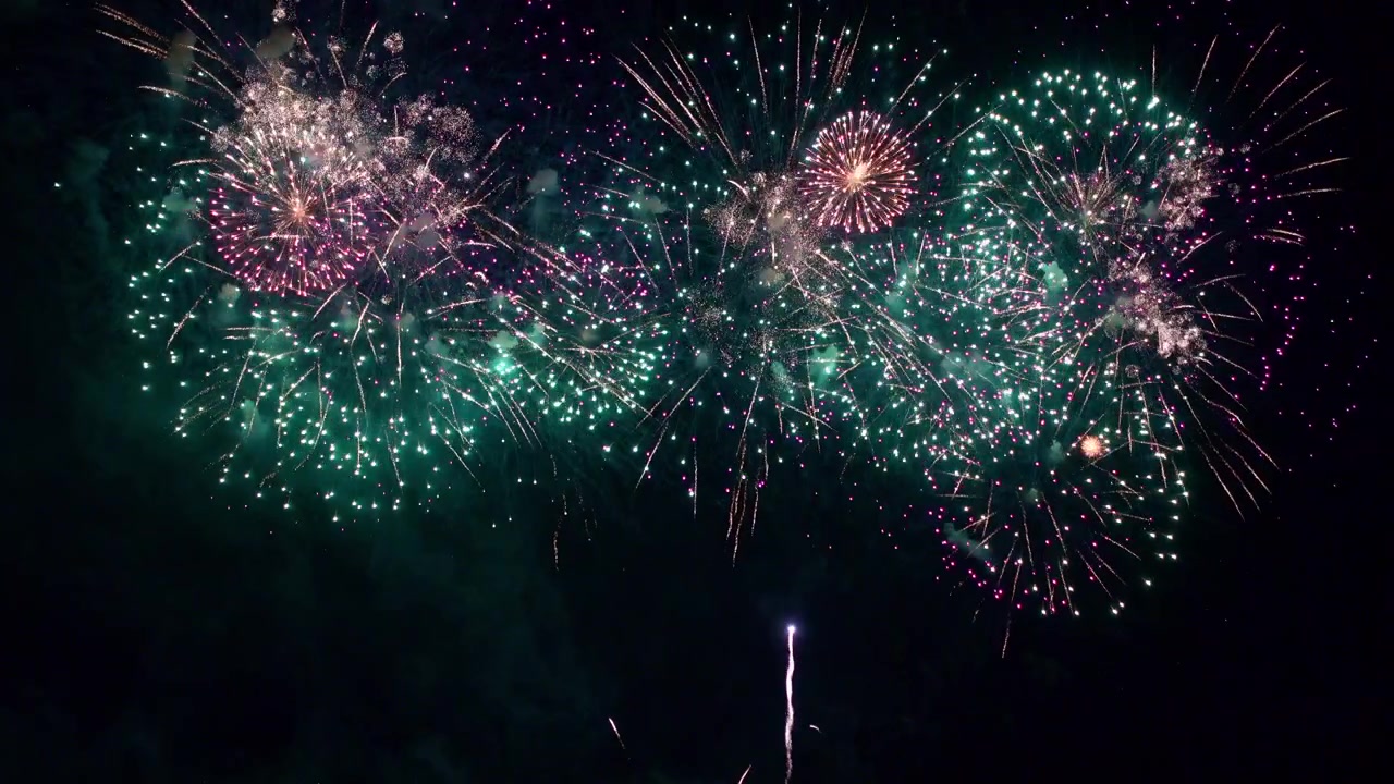 Explosions of color burst against black night sky as fireworks erupt