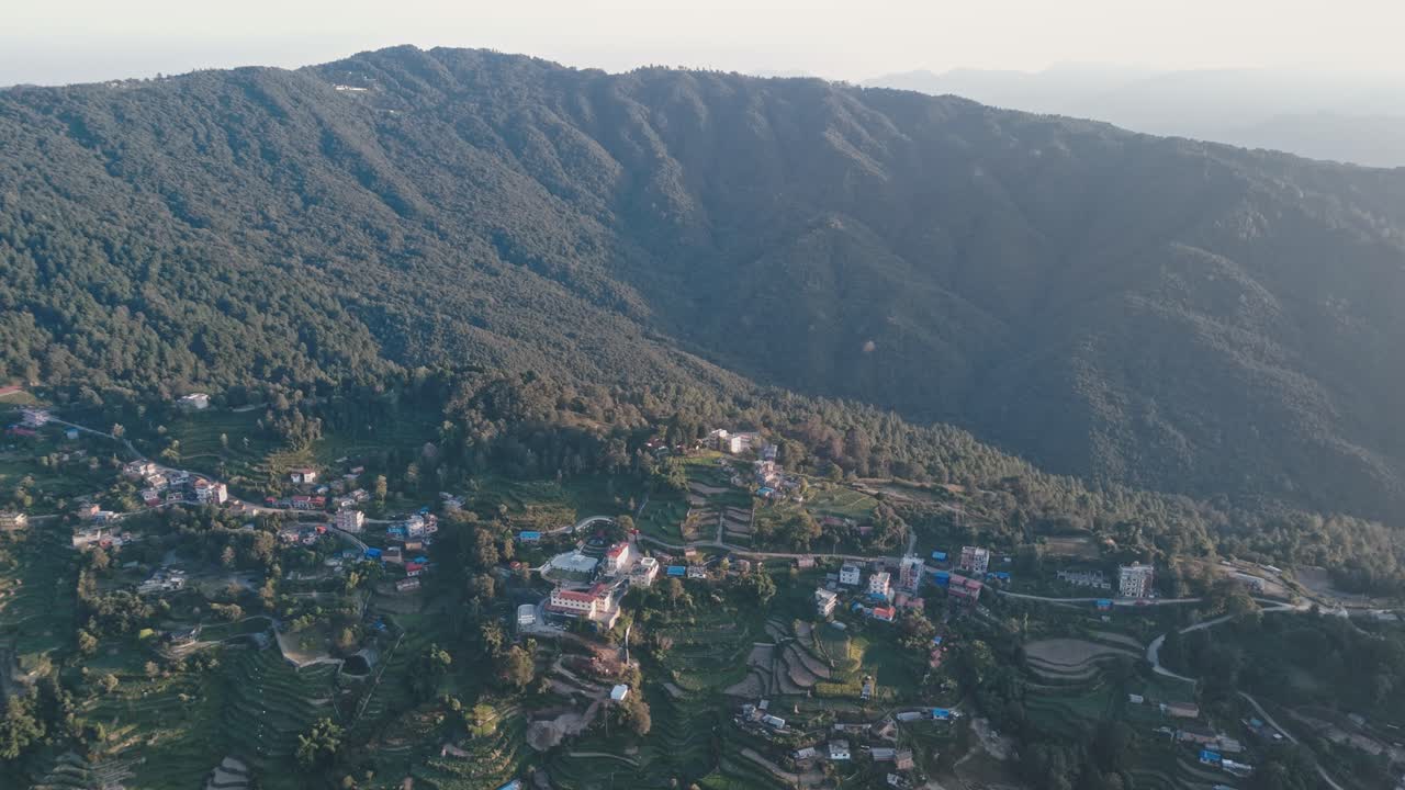 Aerial drone footage of Nagarkot, Nepal, showcasing lush green mountains, peaceful village settlements, and winding hillside roads that highlight the region’s natural beauty and serene landscape