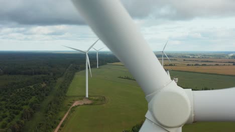 close up of a rotating wind turbine with turbine park in background