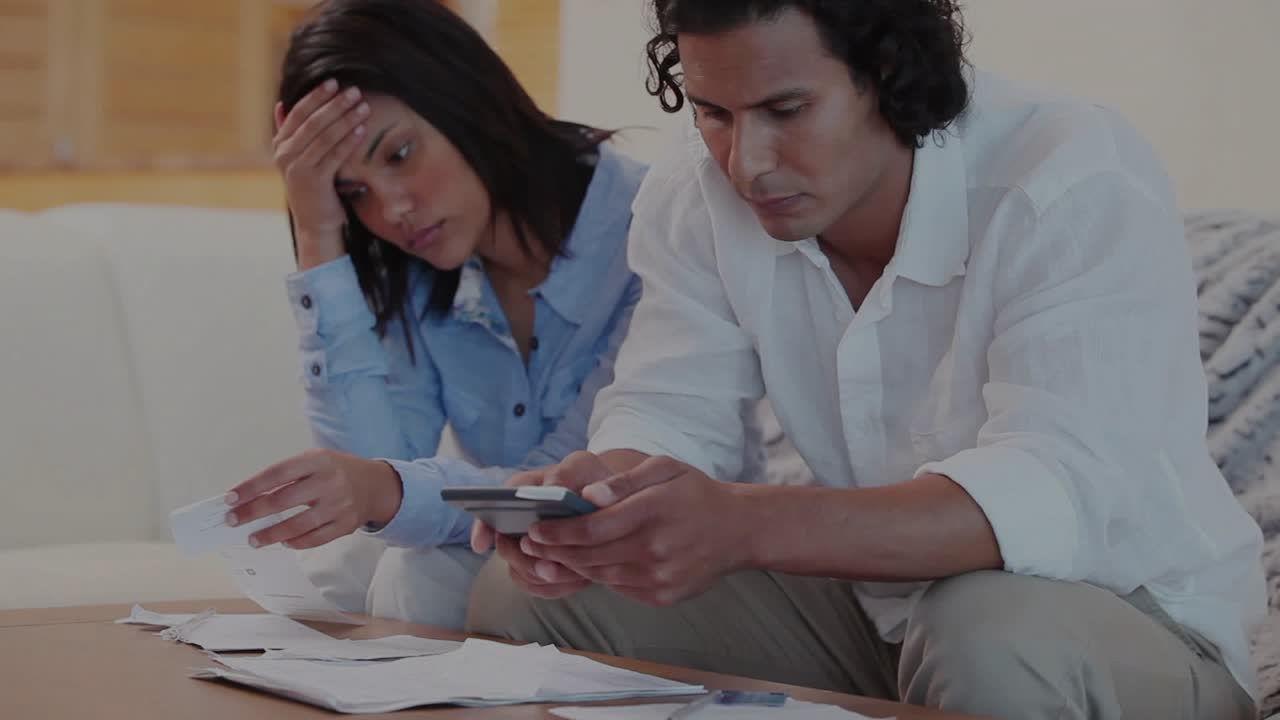 Man tapping phone woman holding bills calculating finances as blue overlay drifting over papers