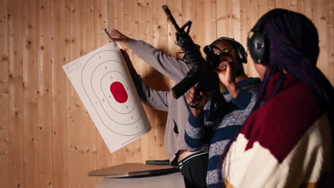 group of friends in firing range shooting targets, wearing earmuffs