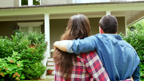 rear view of loving couple looking at house