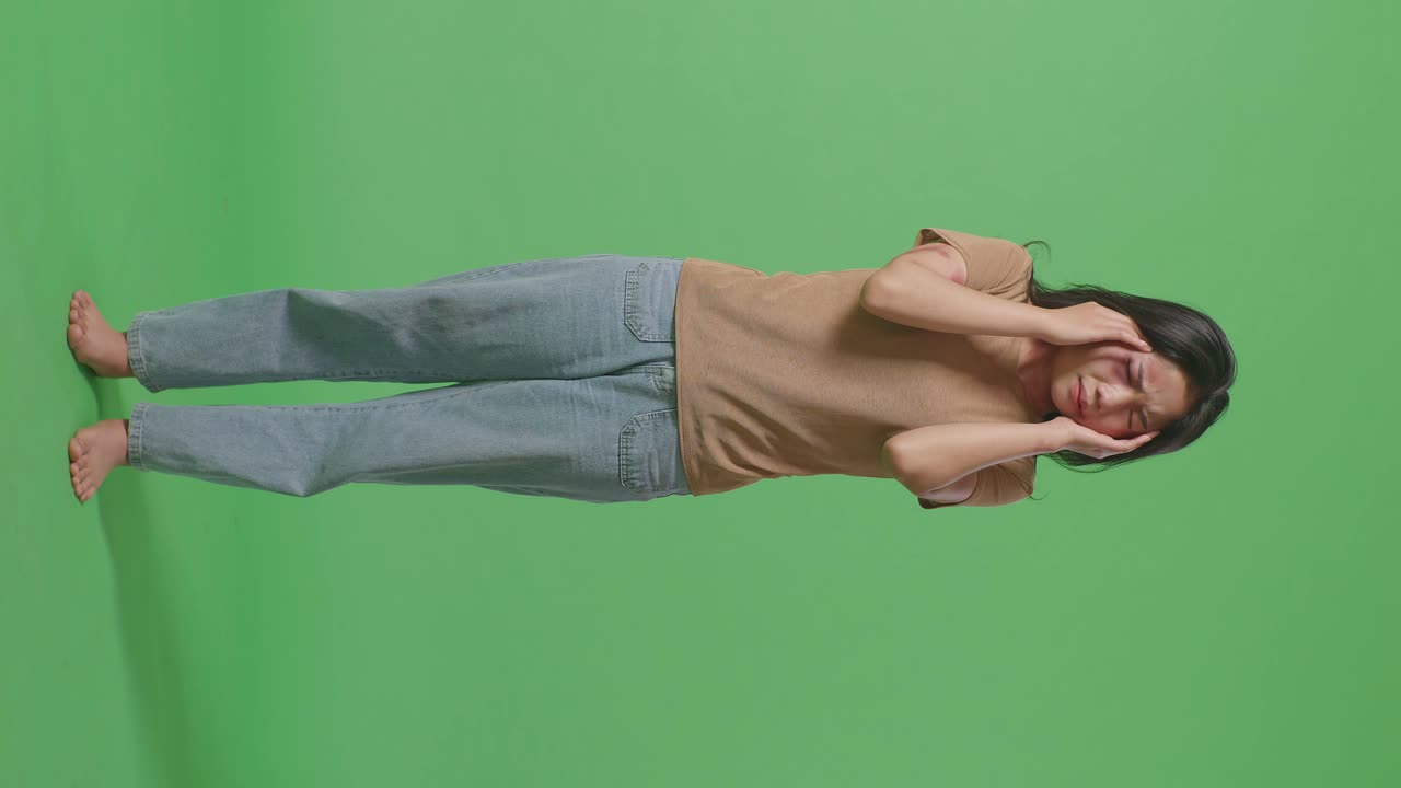 тело молодой азиатской женщины, жертвы насилия с синяками на теле, стресс и головная боль в зеленом экране фоновой студии