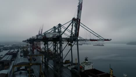 port scene amidst fog: towering cranes and shipping vessels in a misty maritime environment symbolizing industrial activity and transportation dynamics