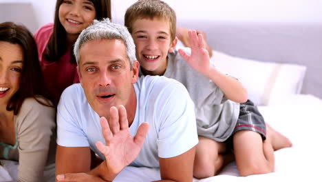 Family-saying-hello-on-a-bed