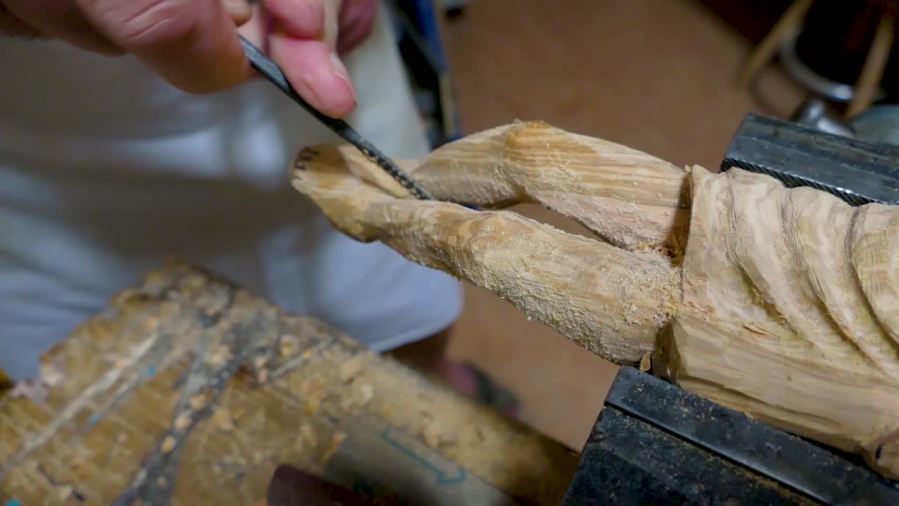 Italian Sculptor in his workshop working on a olive wood statue