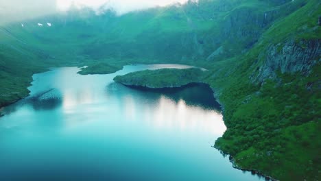 Approaching-panning-drone-shot-of-surrounding-rocky-hills-over-lake-Ågvatnet-in-Lofoten