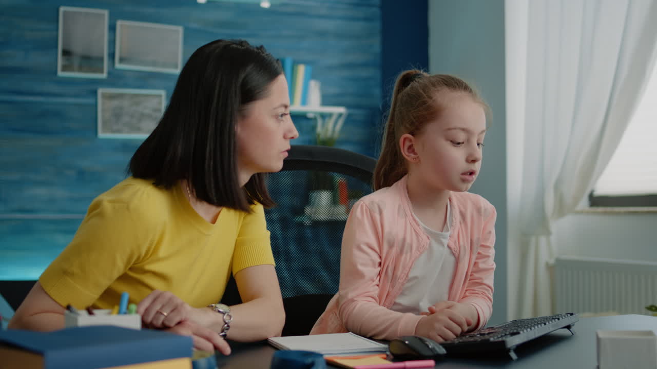 Parent and little girl doing homework together at desk