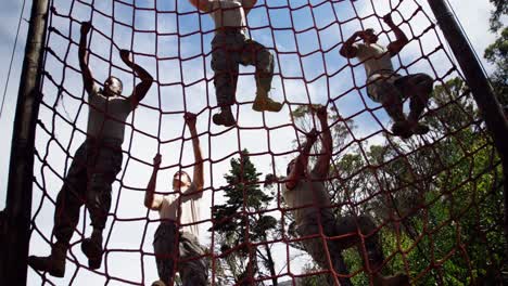 military troops climbing a net during obstacle course 4k