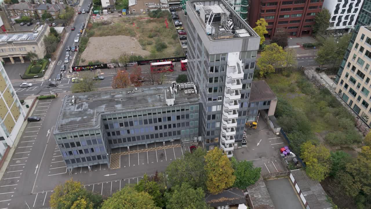 Rising aerial view of deteriorating vacant office building with modernist architecture awaiting redevelopment in Ealing, London, UK, October 2024