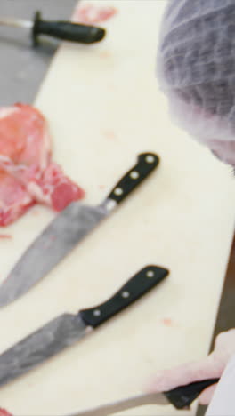 butcher cutting raw meat