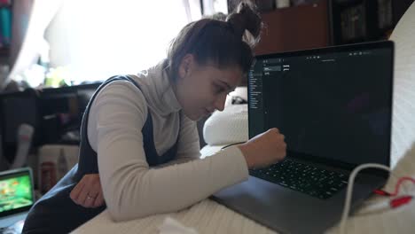 mujer joven trabajando en una computadora portátil en casa