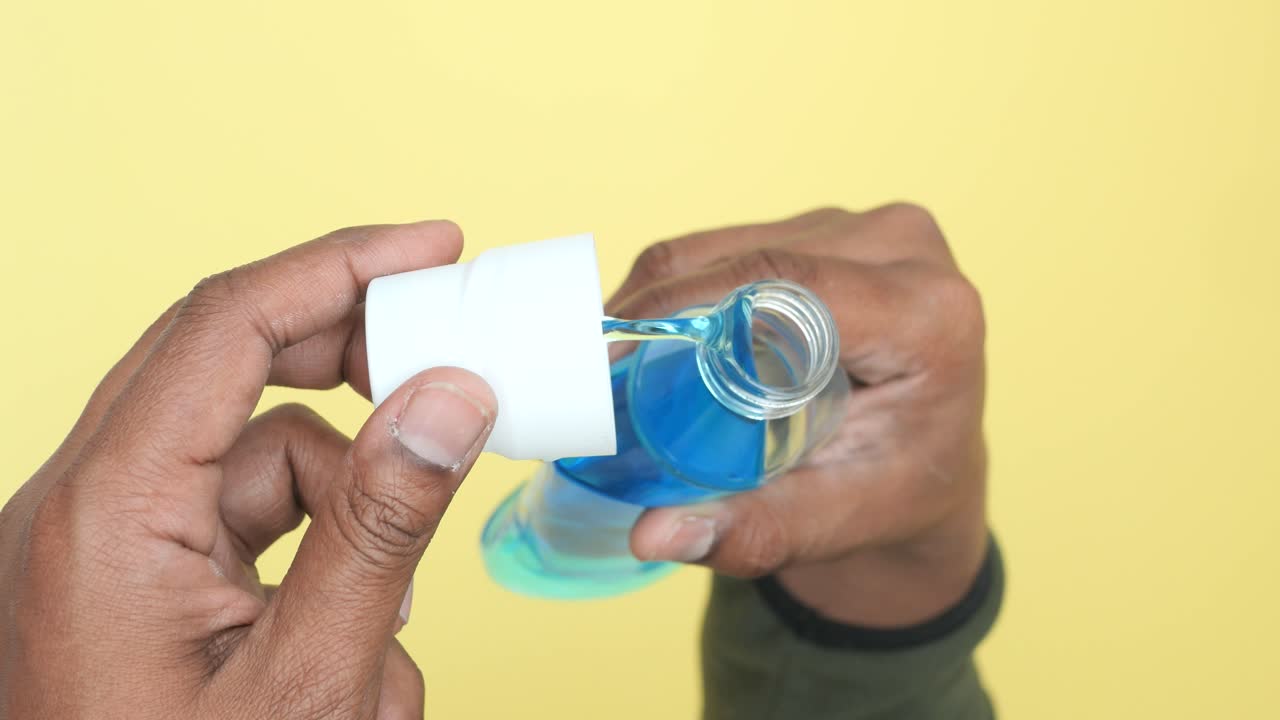 Pouring mouthwash from a bottle