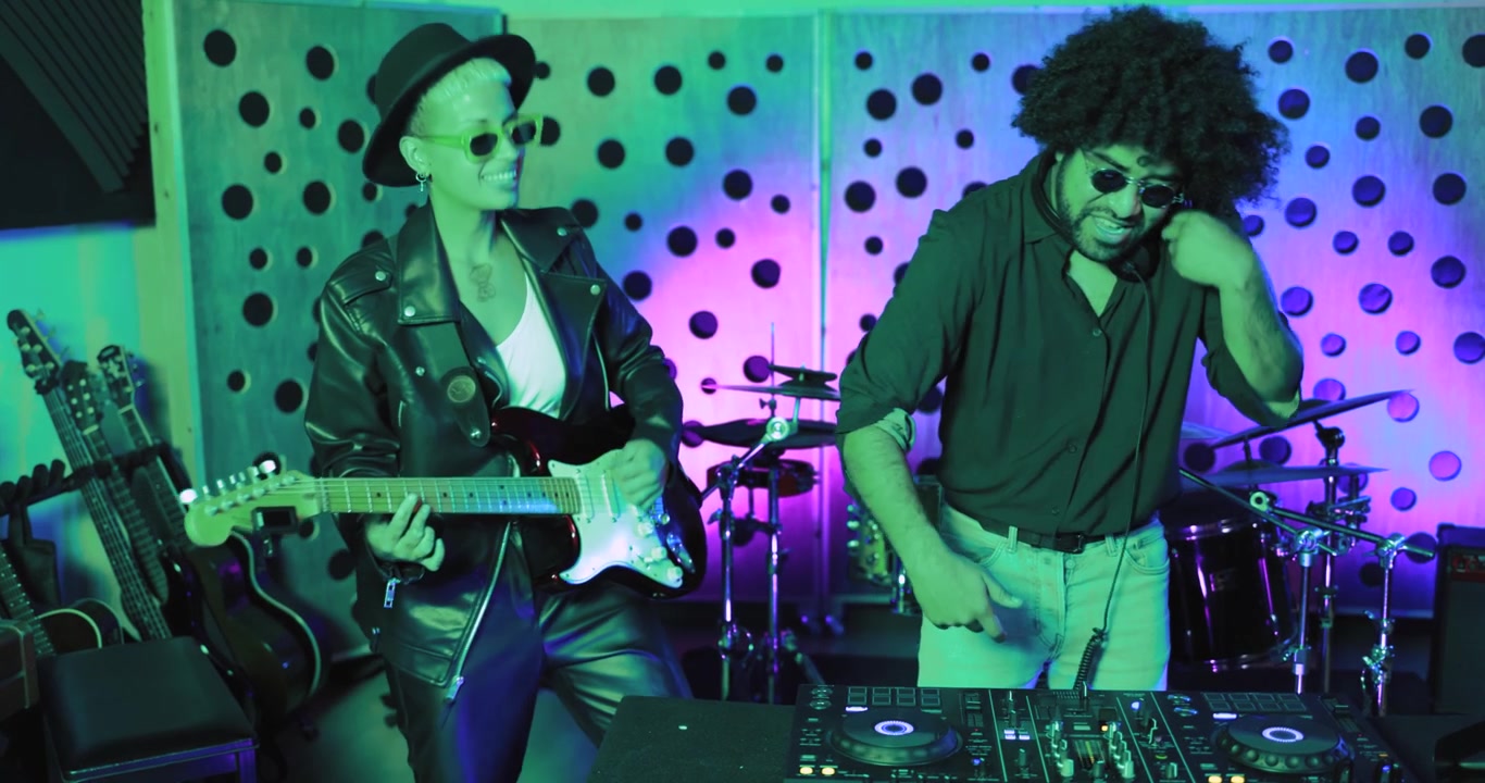 DJ e chitarrista energici che creano musica in uno studio vivace