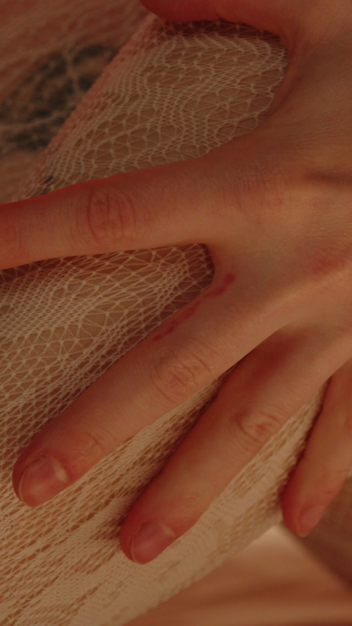 Beautiful vertical macro of a hand pulling and caressing the white stockings being worn by an attractive woman