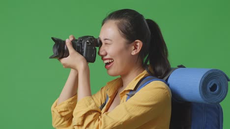 woman with backpack and camera on green screen