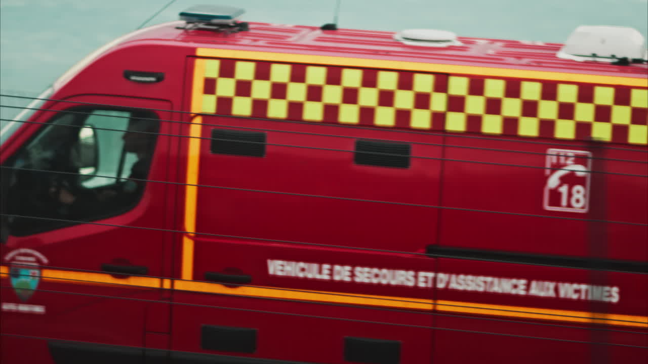 View from a moving train of a red ambulance on the streets of Nice, France