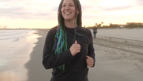 mujer con trenzas corriendo feliz en la playa