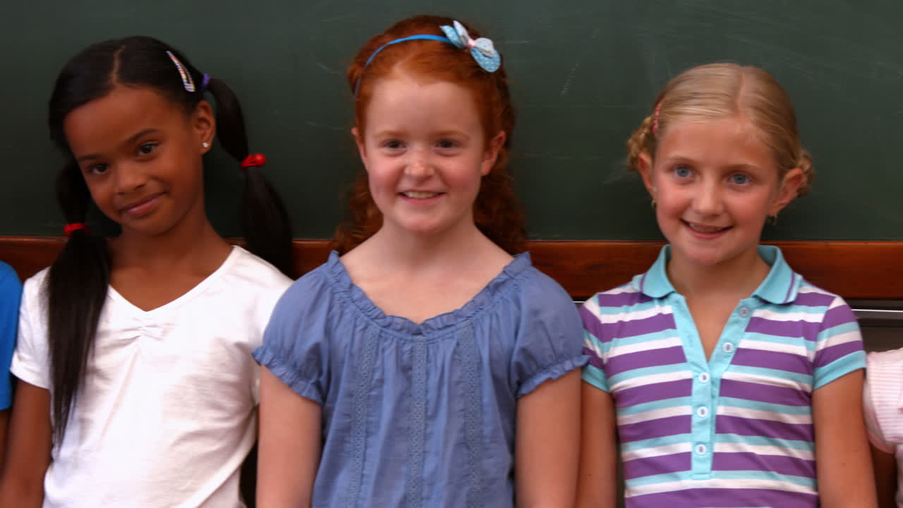 alumnos lindos sonriendo a la cámara en el aula