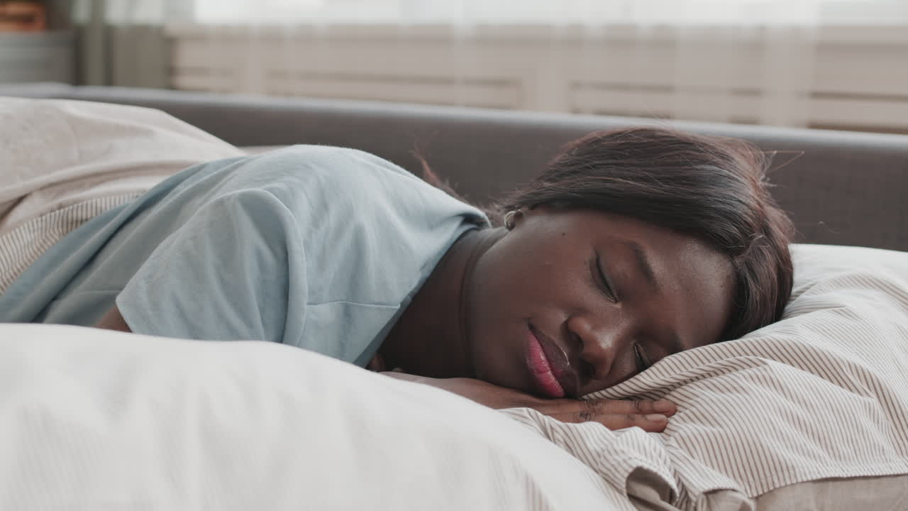Young African Woman Sleeping in Bed