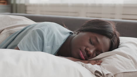 Young African Woman Sleeping in Bed