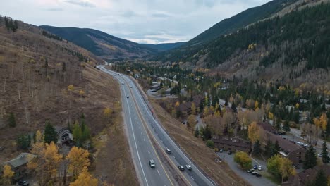 highway roads along mountain slopes, showcasing autumn colors in full display under overcast shadowy sky in the valley, vail colorado