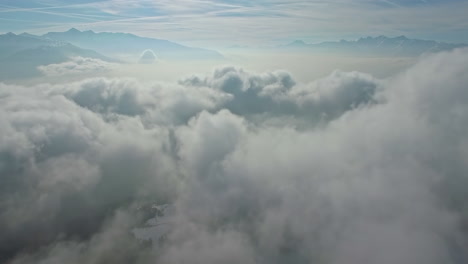 Flauschige-Wolkenlandschaft-Und-Berge-Am-Horizont,-Drohnenansicht-Aus-Der-Luft