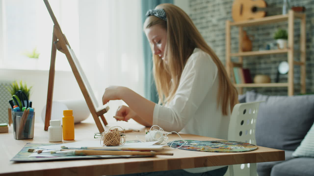 молодая женщина рисует дома