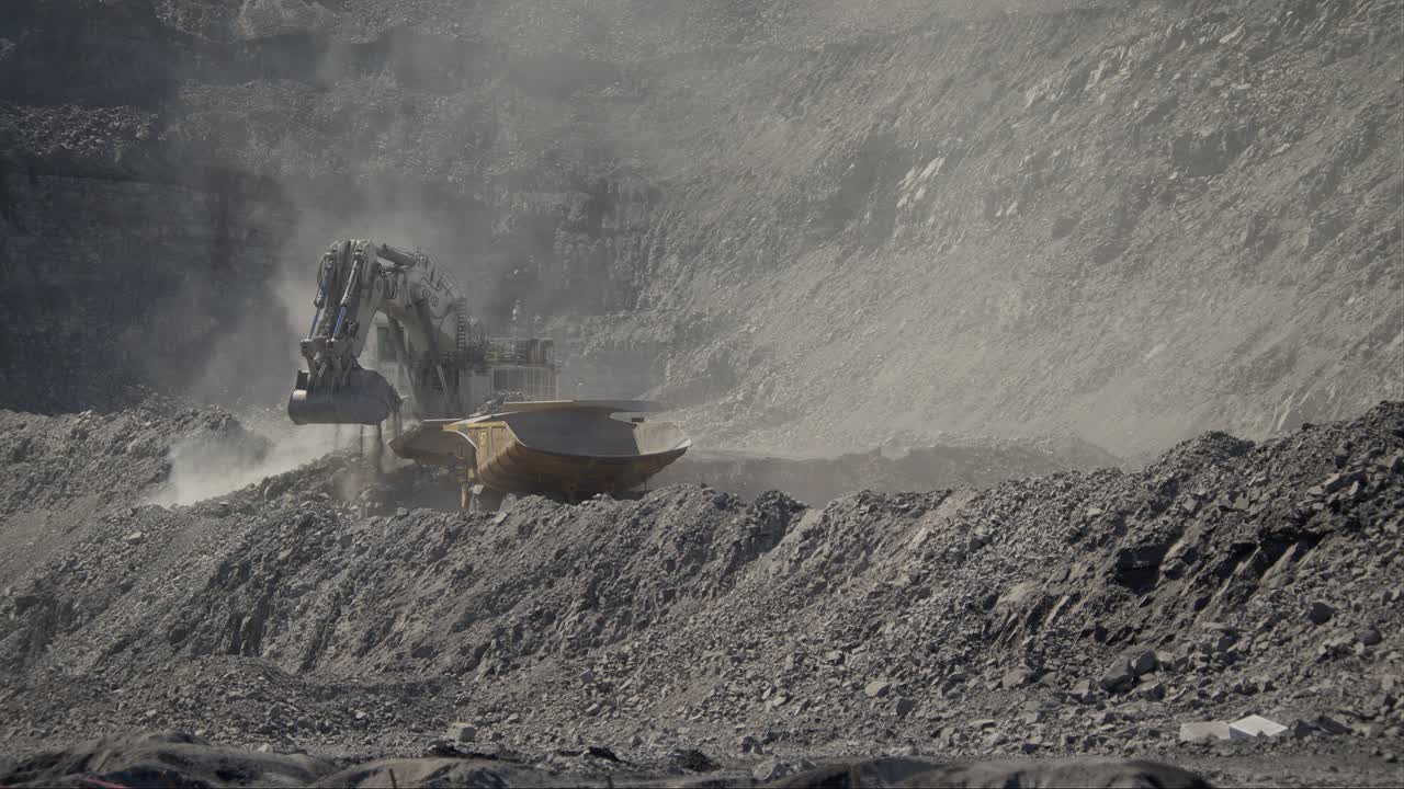 Slow motion excavator loading a truck in a mine