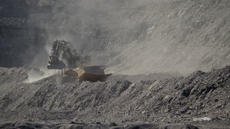 excavadora a cámara lenta cargando un camión en una mina