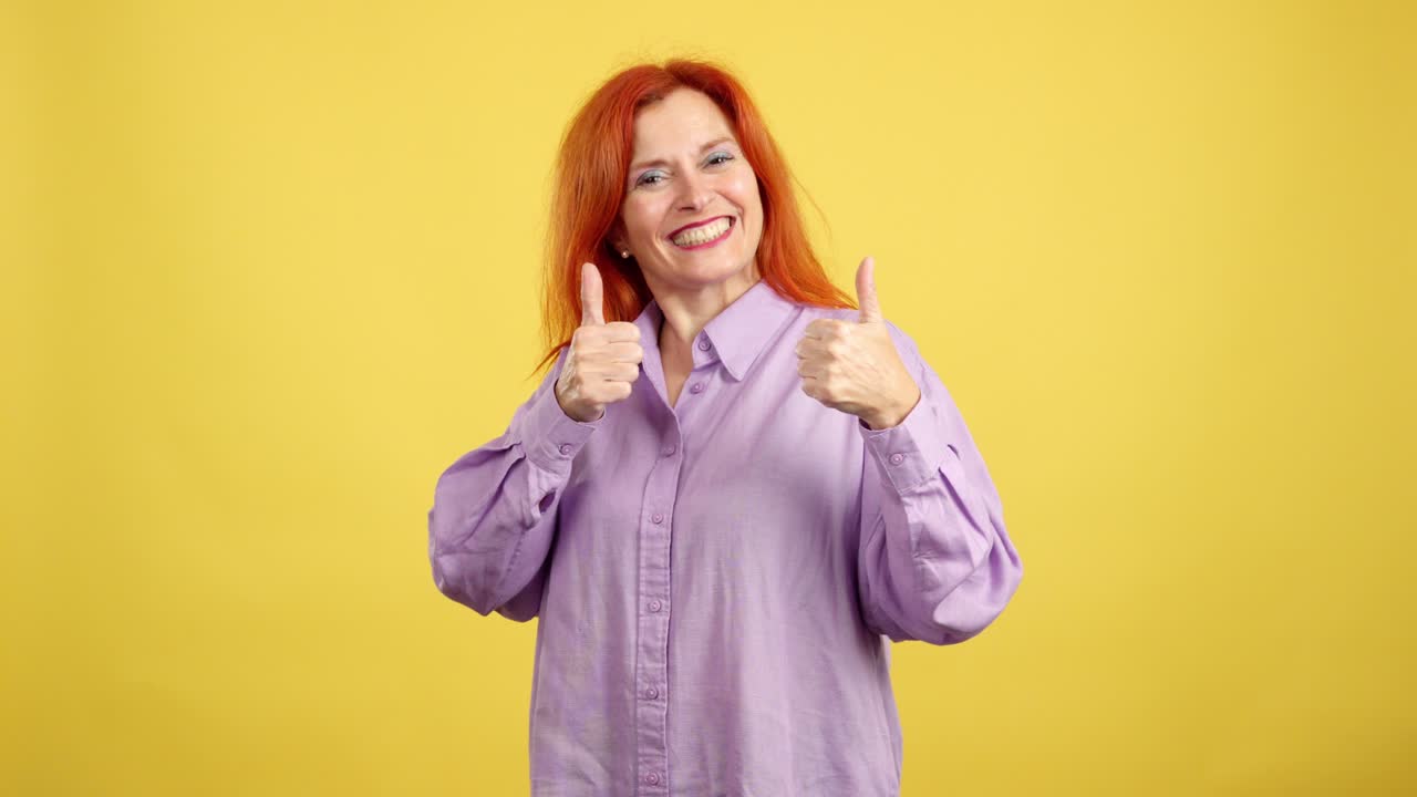 A woman with red hair gives thumbs up gestures