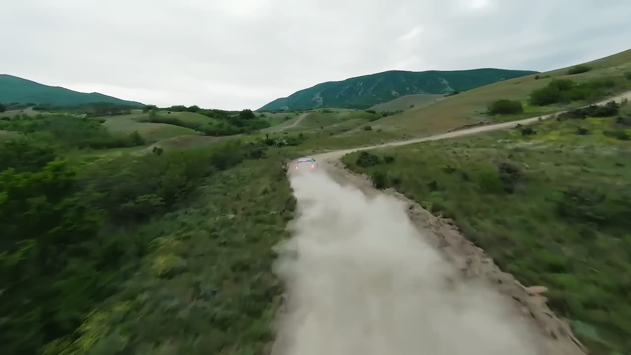 coche conduciendo en un camino de off-road polvoriento en las montañas