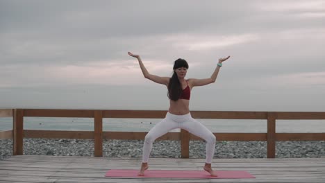 woman practicing yoga on a beach