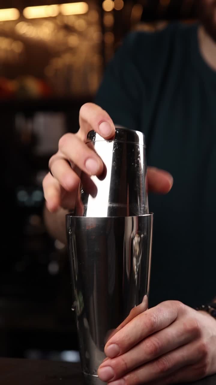 Primo piano di un barista che agita un cocktail in uno shaker